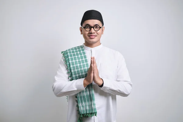 stock image Asian Muslim man wearing white clothes smiling to give greeting during Ramadan and Eid Al Fitr celebration standing over white background