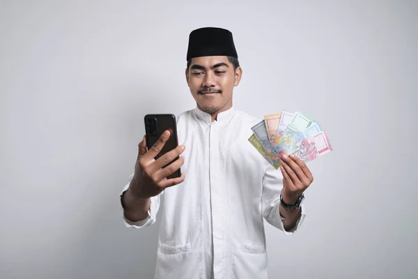 Podekscytowany Azjatycki Muzułmanin Nosi Czapkę Okulary Trzymając Smartfon Pokazując Rękę — Zdjęcie stockowe