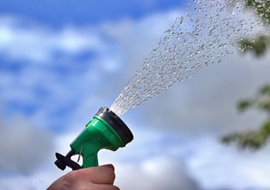 Su tesislerine spreyli hortum kullanan el.