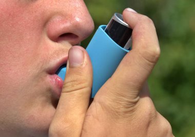 Açık havada mavi astım spreyi kullanan birini kapat.