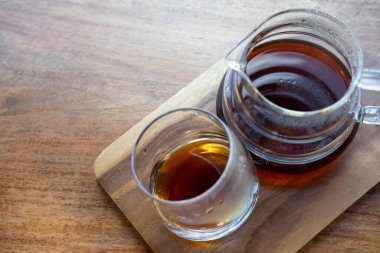 Tahta tabakta bardakla sıcak kahve servisi yap.