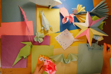 İlkokul çocuğu kendi yaptığı origamiyle oynuyor.
