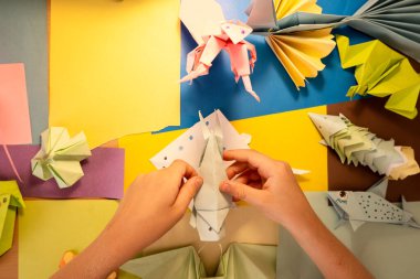 İlkokul çocuğu kendi yaptığı origamiyle oynuyor.