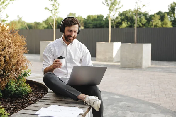 Friendly Male Freelancer Enjoying Coffee While Using Laptop Online Conference Zdjęcia Stockowe bez tantiem
