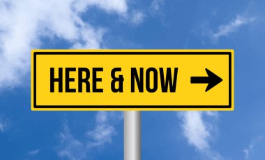 & Şimdi mavi gökyüzü arkaplanındaki yol işareti