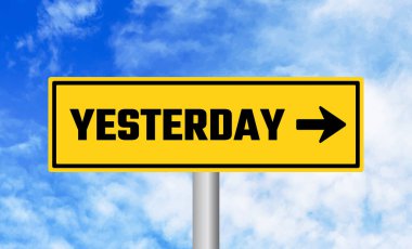 Bulutlu arka planda dün yol tabelası