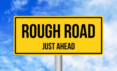 Gökyüzü arka planında Rough Road tabelası var.