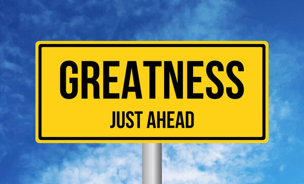 Greatness just ahead road sign on blue sky background