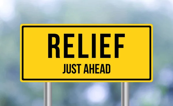 stock image Relief just ahead road sign on blur background