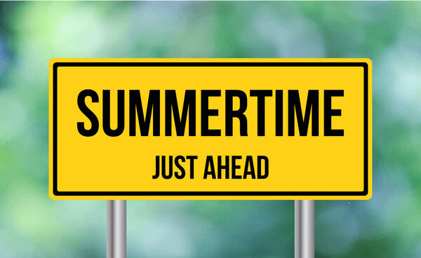 Summertime just ahead road sign on blur background