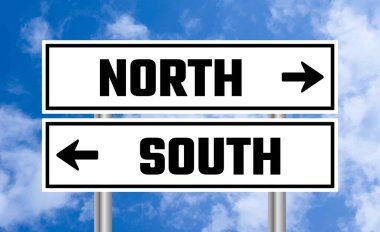 Mavi gökyüzü arka planında kuzey ya da güney yol işareti