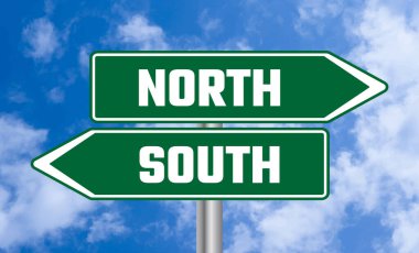 Mavi gökyüzü arka planında kuzey ya da güney yol işareti