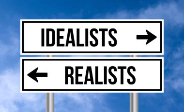 Gökyüzü arka planında idealistler ya da realistler yol tabelası
