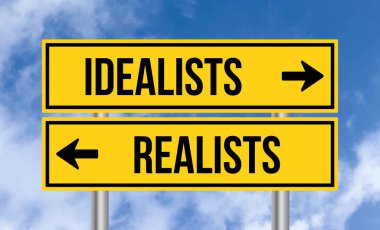 Gökyüzü arka planında idealistler ya da realistler yol tabelası