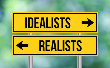 Bulanık arka planda idealistler ya da realistler yol tabelası