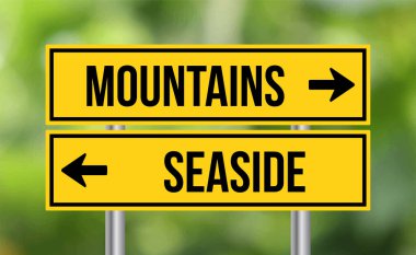 Bulanık arkaplanda dağlar ya da sahil yolu tabelası