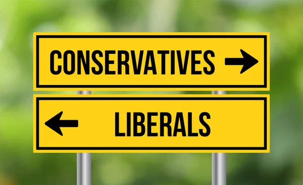 保守派やリベラル派の道路標識がぼやけた背景に — ストック写真