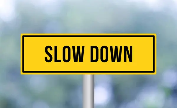 stock image Slow down road sign on blur background