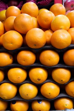 Yakın plan çekimde siyah tepsilerde düzenlenmiş bir yığın portakal yakalar. Canlı renklerini ve satılık kumaşlarını sergiler..
