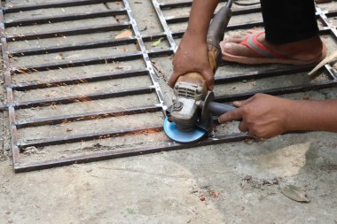 Hint zanaatkârının metal ızgaraları öğütmesi, dışarıda gündüz vakti el bilgisayarıyla turuncu kıvılcımlar yaratması, tehlikeli bir iş..