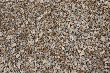 Arka planda, doğal, küçük, açık kahverengi ve gri taşların, tam kare, pürüzsüz bir desen içinde rastgele sıralandığını görüyoruz..