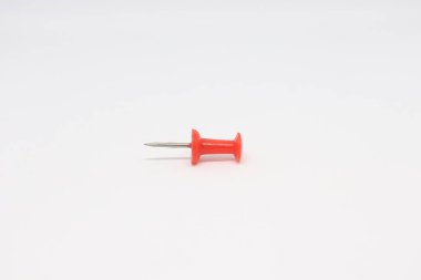 Bu resim, temiz beyaz zemin üzerine kurulmuş gümüş iğneli kırmızı bir iğnenin yakın plan çekimini gösteriyor, çeşitli amaçlar için ideal..