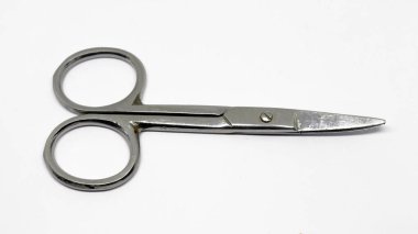 Yakın plan, parlak bir stüdyo ortamında beyaz bir arka planda izole edilmiş yuvarlak saplı ve kısa bıçaklı metal tırnak makası gösteriyor..
