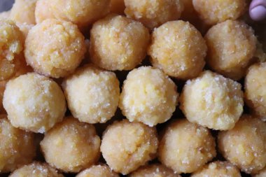 Yuvarlak Hint tatlıları, şekerli granüllü Motichoor Ladoo. Şenlikli mutfağı, kültürel mirası ve paylaşılan kutlamaların neşesini temsil eder..
