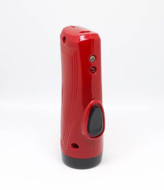 Kapalı çekim stüdyosu, siyah düğmeli, silindirik kırmızı plastik bir objeyi sergiliyor. Öge pürüzsüz bir yüzeye sahiptir ve beyaz bir arkaplana karşıdır.