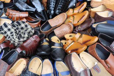 Tam tepede çeşitli kahverengi, siyah ve mavi renklerde çeşitli deri mokasenler ve sandaletler var. Tarz çeşitliliği sunuyorlar..