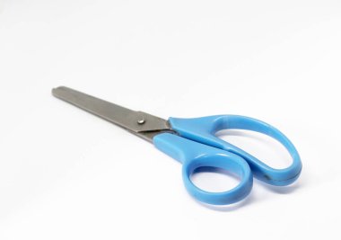 Açılı göz mermisi, arka planda mavi saplı metal makas içerir. Beyaz bir düzlemde kesişen bıçaklarla kesişen bir alet..