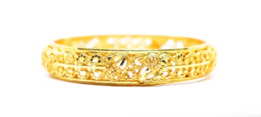 Özenle hazırlanmış, parlak altın bir bilezik, saf beyaz bir arka plan üzerine kuruludur ve geleneksel Hint mücevherleri sergilenir..