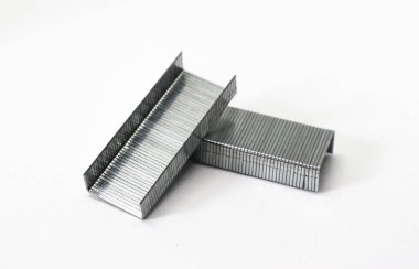 İki metalik zımba, tek tek zımbaların detaylarını gösteren katıksız beyaz bir arkaplan karşısında hafifçe dengelenmiş..