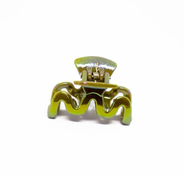 Kapalı çekimde, el değmemiş beyaz bir zemin üzerine kurulmuş, kendine özgü dalgalı bir tasarımı olan küçük, yeşil, plastik bir pençe saç tokası sergileniyor..