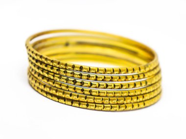 Altın tonlu bilezik koleksiyonu, katmanlı, karmaşık altın işleme tasarımı beyaz bir yüzeyde sergilenen detaylar.