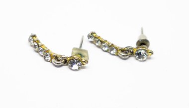 Two glittering ear climbers feature a gold-tone metal and clear simulated diamonds on a white background, revealing details in shape and texture.