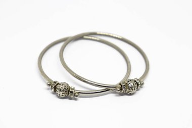 Dekoratif boncuklu iki gümüş bileziğin temiz beyaz arka planda çekilmiş yakın plan çekimi. Çekim aksesuarları vurguluyor..