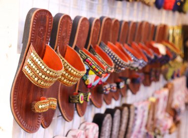 El yapımı etnik Kolhapuri ahbapları. Deri sandaletlerde canlı boncuklu kayışlar, gösterişli Hint el işi. Kültür meraklıları için eşsiz ayakkabılar.