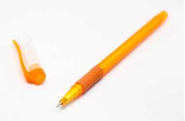 Açık, turuncu, tükenmez kalemle kapağı beyaz bir arka planda duran ve yazı yazmak için ideal desenli bir kabzaya sahip yakın plan fotoğrafı..