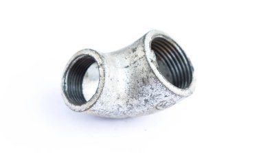 Sağlam bir galvanizli metal tişört borusuna yakın çekim. Endüstriyel tesisat bileşeni temiz beyaz bir zemin üzerinde başlıklı bir bağlantı içeriyor..