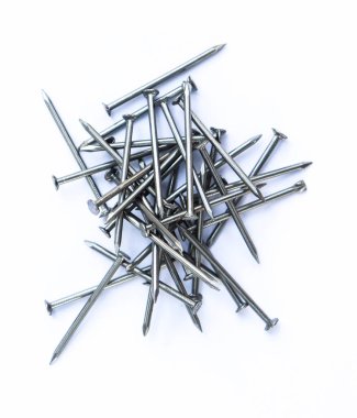 Yakın plan çekimde gümüş renkli metal çiviler görülebilir noktalar ve kafalara sahipler, düz beyaz bir arkaplanda düzgünce düzenlenmiş, minimalist bir natürmort oluşturuyorlar..