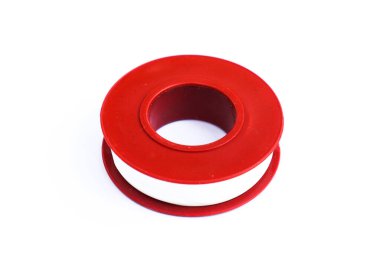 Stüdyoya yakın çekim, beyaz arka planda izole edilmiş beyaz bir şerit tutan kırmızı plastik bir makarayı gösteriyor..