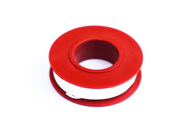 Kapalı çekimler beyaz bantla sıkıca sarılmış kırmızı plastik bir makara, titiz beyaz bir zemin üzerine yerleştirilmiş..