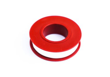 Yükseltilmiş yakın çekim vitrinleri, beyaz bantla sımsıkı sarılmış canlı kırmızı bir plastik makara. Temiz, parlak beyaz arka plan canlı kırmızı makarayı vurguluyor..