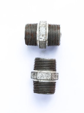 Yakın planda iki galvanizli demir boru var. Biri paslı, biri hafif hasarlı. Temiz, şeffaf beyaz bir zemin üzerinde..