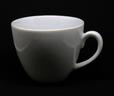 El değmemiş beyaz seramik kahve fincanı tek başına duruyor, kıvrımlı şekli, sıcaklığı ve sadeliği simsiyah bir zemine yayıyor, zarafet katmak için mükemmel..