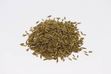 Beyaz bir yüzey üzerinde kurutulmuş kimyon tohumu yığınını gösteren yakın çekimde, onun mutfak kullanımı ve zengin, topraksı lezzeti vurgulanıyor, gıda hazırlığı için ideal..