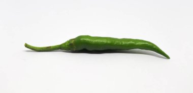 Tek, kesilmemiş, parlak yeşil kırmızı biber merkezi olarak temiz beyaz bir arka plan üzerine yerleştirilmiş, şeffaf derisini ve doğal kıvrımını mutfak veya ürün görselleştirmesi için sergiliyor..