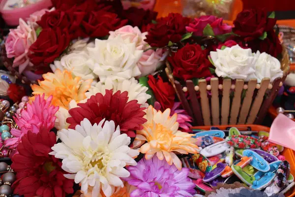 Kırmızı, pembe ve beyaz renklerde canlı güller ve papatyalar dikkat çekici bir çeşitlilik yaratır. Saç tokaları ve güzel bir ekran için ahşap bir sepet ile dikkatlice düzenlenir..