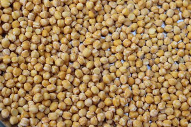 Bu resim pek çok canlı, kurumuş bezelyenin tam bir çerçevesini gösteriyor. Bezelyeler sıkıca paketlenir ve doğal dokuyu vurgulayan dokulu bir arkaplan oluşturulur..